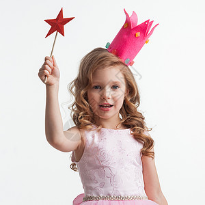 美丽的糖果公主女孩皇冠上着星星形状的魔杖,并白色的背景上做了个愿望咒语公主女孩带着星星魔杖背景图片