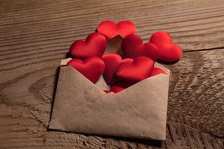 情人节情书,信封用红心堆铺木底情人节情书背景图片