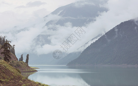 平静的景色加大的山湖旁边,岩石平静的水中反射图片