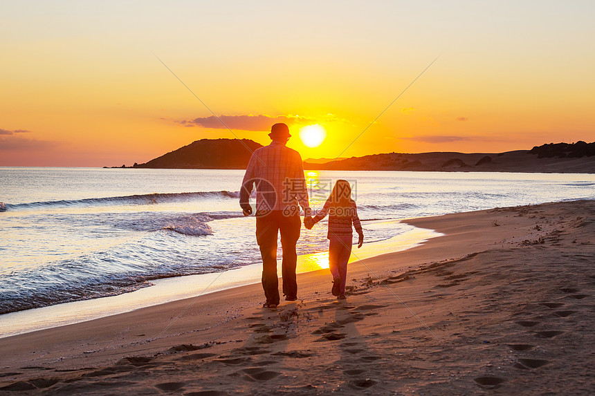 日落时海滩上的家人母亲女儿起跑步图片