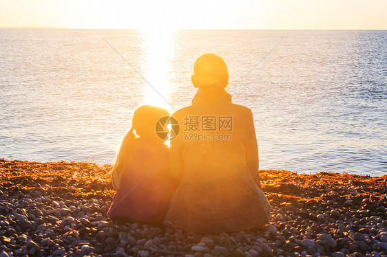 日落时海滩上的家人母女俩起跑步图片