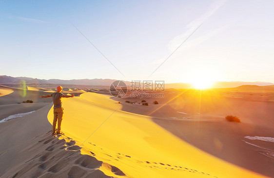 沙漠里的徒步旅行者日出时间图片
