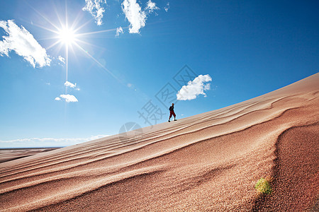 沙漠里的徒步旅行者日出时间图片