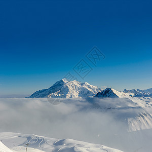 高山冬山景观低云阳光明媚的日子里,法国阿尔卑斯山上覆盖着雪瓦尔drsquoIsere,法国图片