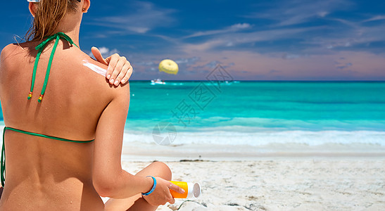 海滩上的谭女士涂防晒霜保护乳液图片