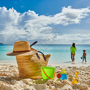 三岁的蹒跚学步的男孩妈妈海滩上沙滩袋玩具塞舌尔马赫的暑假家庭假期图片