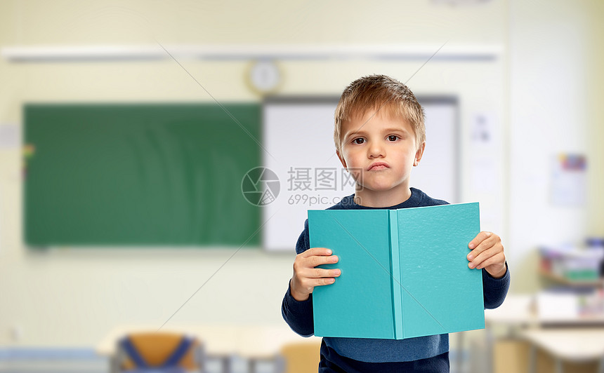 学校,教育学高兴的小男孩阅读书籍的课堂背景学校里,小男孩喜欢书图片