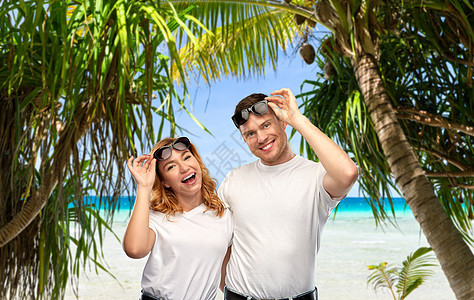 旅行,旅游暑假幸福夫妇的肖像,白色T恤太阳镜热带海滩背景法属波利尼西亚热带海滩上戴太阳镜的幸福夫妇图片