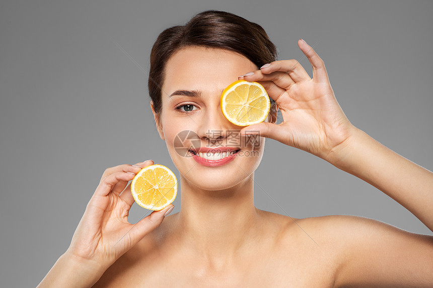 美容,护肤排美丽的女人做眼罩柠檬片灰色背景美丽的女人用柠檬片做眼罩图片