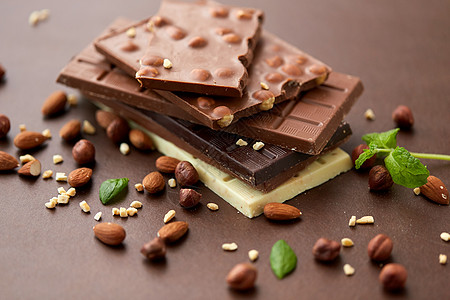 糖果,糖果食品黑,白色牛奶巧克力与坚果棕色背景同的巧克力棒坚果图片