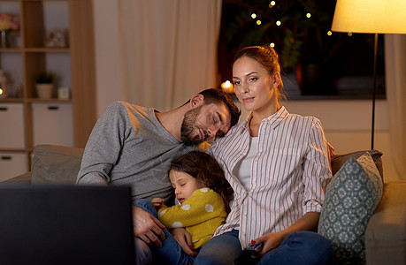 家庭,休闲人的父亲小女儿睡觉,而母亲晚上家看电视疲惫困倦的家人晚上家看电视图片
