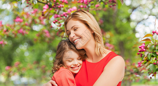 家庭,母亲人的幸福微笑的母亲女儿拥抱樱花背景快乐的母女拥抱花园图片