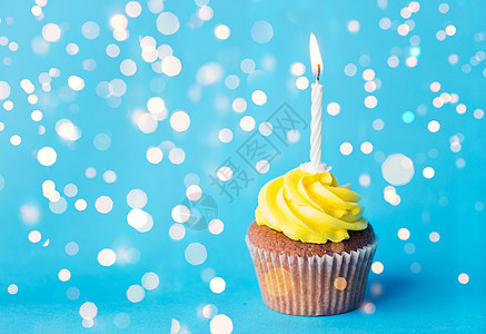 节日,庆祝,问候派生日蛋糕与黄色奶油霜个燃烧蜡烛节日灯上的蓝色背景生日蛋糕支燃烧的蜡烛图片