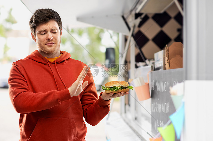 快餐,健康的饮食人们的年轻人穿着红色连帽衫,拒绝汉堡食品卡车街头背景年轻人拒品卡车上吃汉堡包图片