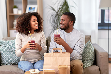 饮食人的快乐的非裔美国人夫妇带着外卖食品饮料家幸福的夫妇带着外卖食品饮料家图片