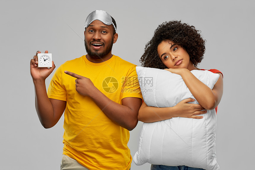 早上,睡觉时间人的非裔美国人夫妇有闹钟,眼罩枕头灰色背景带闹钟睡觉面罩枕头的夫妇图片
