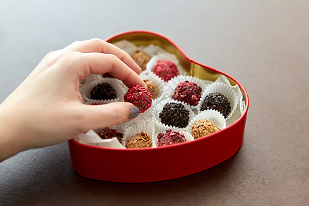 糖果,糖果食品手与糖果红色心形巧克力盒棕色背景手与糖果心形巧克力盒图片