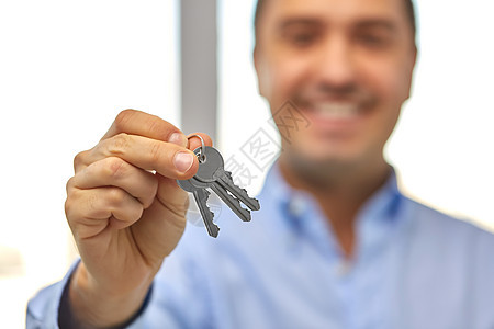 房地产,住房人的近距离微笑的人着房子的钥匙靠近微笑的男人着房子的钥匙图片