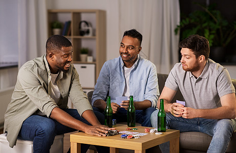 休闲游戏,友谊的快乐的男朋友家里晚上打牌喝啤酒快乐的男朋友晚上家打牌图片