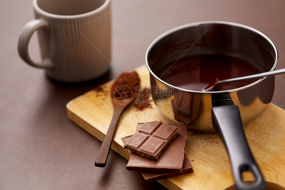 糖果,糖果烹饪锅与融化的热巧克力,可可粉勺子,陶瓷杯木板棕色背景锅里有热巧克力杯子可可粉图片