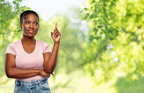 人,想法注意力快乐的非裔美国年轻妇女指着绿色的自然背景快乐的非裔美国妇女指指点点图片