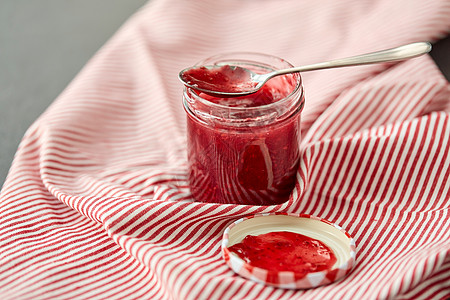食物,蜜饯饮食梅森罐与红色覆盆子果酱勺子毛巾上梅森罐子,覆盆子果酱勺子毛巾上图片