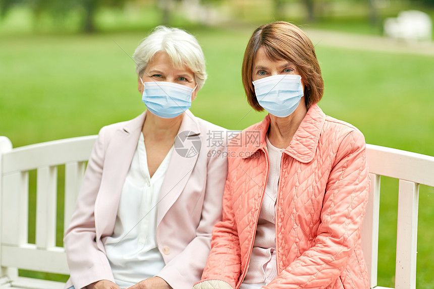 健康安全大流行两名戴医用口罩的高级妇女或朋友夏季公园的长凳上免受病感染公园戴医学面具的高级妇女图片