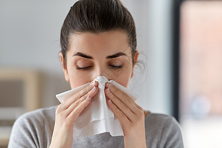 医疗保健,感冒,过敏人的密切生病的女人家里用纸巾吹鼻涕生病的女人家里用纸巾吹鼻子图片