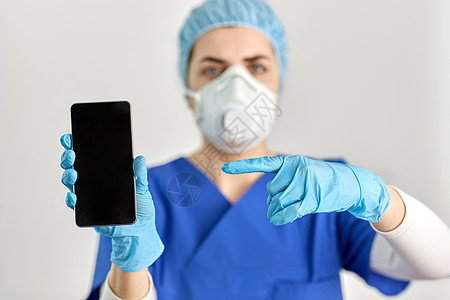 医学健康大流行用智能手机年轻女医生或护士戴面罩或呼吸器以防止病疾病带智能手机的护目镜面罩医生图片