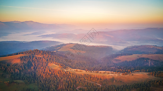 美丽秋山的空中全景日出山间雾谷上早上雾蒙蒙的林地乌克兰喀尔巴阡山脉图片