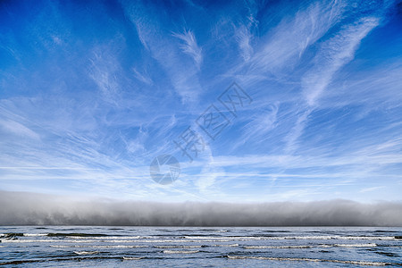 海洋上空多云的天气蓝天下向海岸走来图片