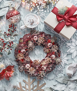 节日圣诞花环与老式圣诞装饰,雪花,礼物盒杯卡布奇诺浅蓝色针织毛毯上面的风景框架假日平躺图片