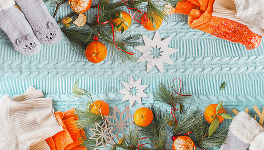 舒适的冬天心情平躺蓝色针织毛毯上,上面有橘子橙色毛衣滑稽的袜子冷杉枝上面的风景图片