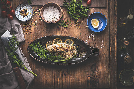 鱼片与柠檬草药背后盘乡村厨房桌子背景与配料上面的风景图片