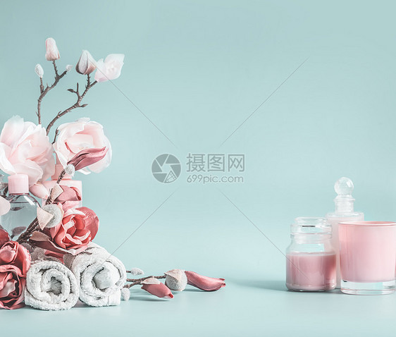 美丽的背景与淡粉色的花化妆品淡蓝色的背景图片