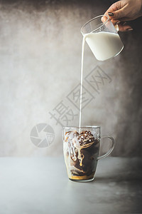 冰咖啡准备女手玻璃中倒入奶油牛奶,混凝土墙背景的乡村桌子上放咖啡冰块冰咖啡制作夏季清爽饮料冷饮图片