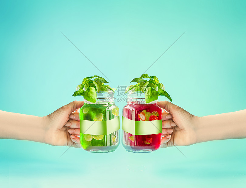 女手品尝夏季饮料红色绿色清爽水果饮料玻璃瓶与品牌模拟阳光明亮的薄荷绿松石背景夏天的心情空白标签健康图片