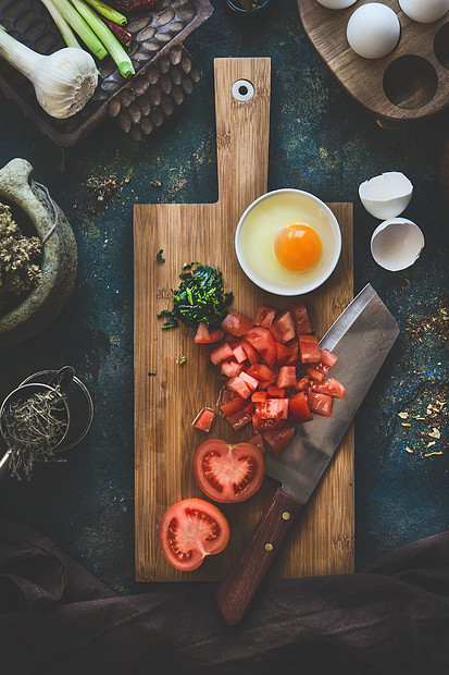 西红柿鸡蛋木制切割板上,刀黑暗的乡村餐桌背景上沙库卡烹饪配料上面的风景健康的食物图片