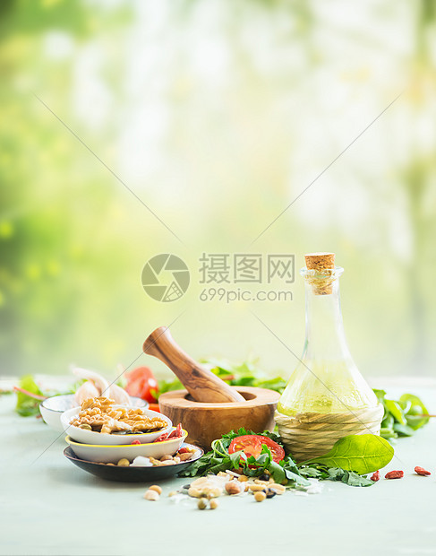新鲜的沙拉配料站夏季自然背景的轻桌上橄榄油,坚果种子,沙拉叶,草药香料健康食品的夏季美食图片