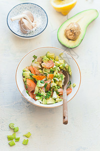 美味的新鲜鳄梨番茄沙拉白色厨房桌子背景,顶部视图健康的食物素食午餐或小吃图片