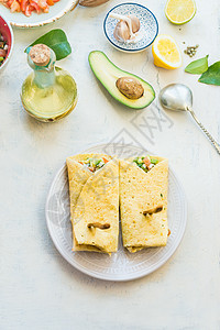美味的玉米饼包装三明治与鳄梨新鲜蔬菜成分轻桌背景,顶部视图健康的食物素食午餐或小吃图片