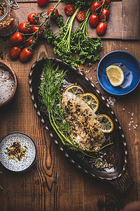 烤鱼片鱼烤形式与迪尔柠檬片木制背景,顶部视图家常菜的海鲜,低碳水化合物节食营养图片