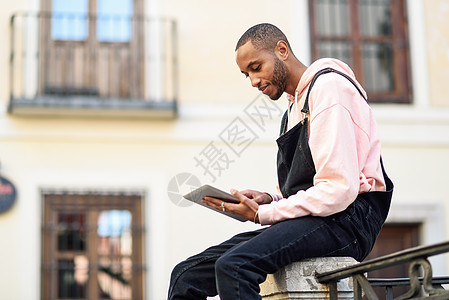 年轻的黑人城市背景下用数字平板电脑生活方式技术年轻的黑人城市背景下用数字平板电脑图片