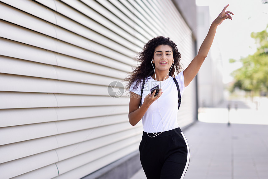 黑人女子戴着耳机户外听音乐图片