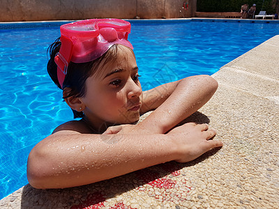 小女孩用粉红色的潜水镜游泳池里洗澡小女孩用潜水镜游泳池里洗澡图片