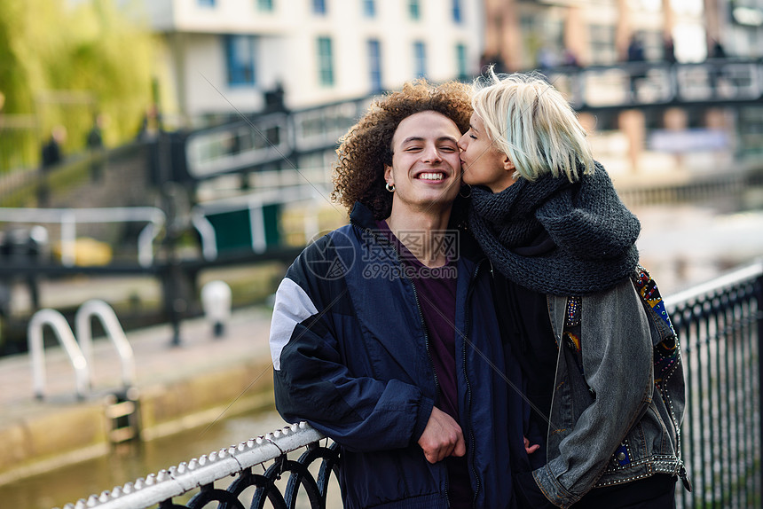 快乐的夫妇伦敦小威尼斯的卡姆登镇玩得很开心英国年轻女子亲吻男友的脸快乐的情侣卡姆登镇小威尼斯玩得开心,图片