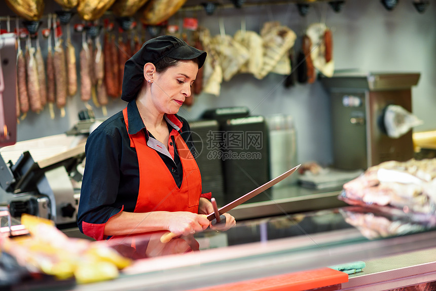 年轻的女屠夫肉店里磨刀屠夫肉店里磨刀图片