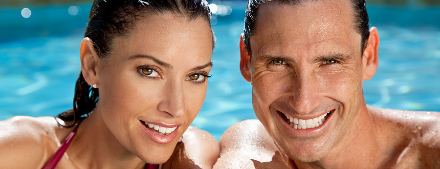 全景肖像,美丽的幸福的男女夫妇休息边的阳光沐浴游泳池微笑与完美的牙齿全景标题图像图片