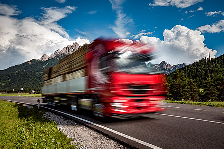 木材卡车阿尔卑斯山的背景下沿着公路飞驰卡车汽车运动模糊图片