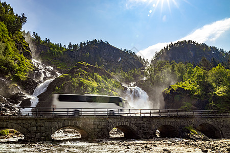 旅游巴士公路上行驶,晚福森瀑布奇达挪威晚期瀑布个强大的孪生瀑布图片